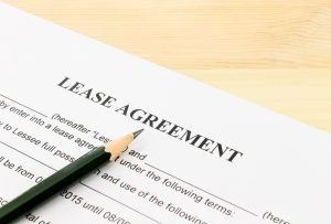 Lease Agreement Contract Document and Pencil Bottom Left Corner on Wood Table. Legal document for business event