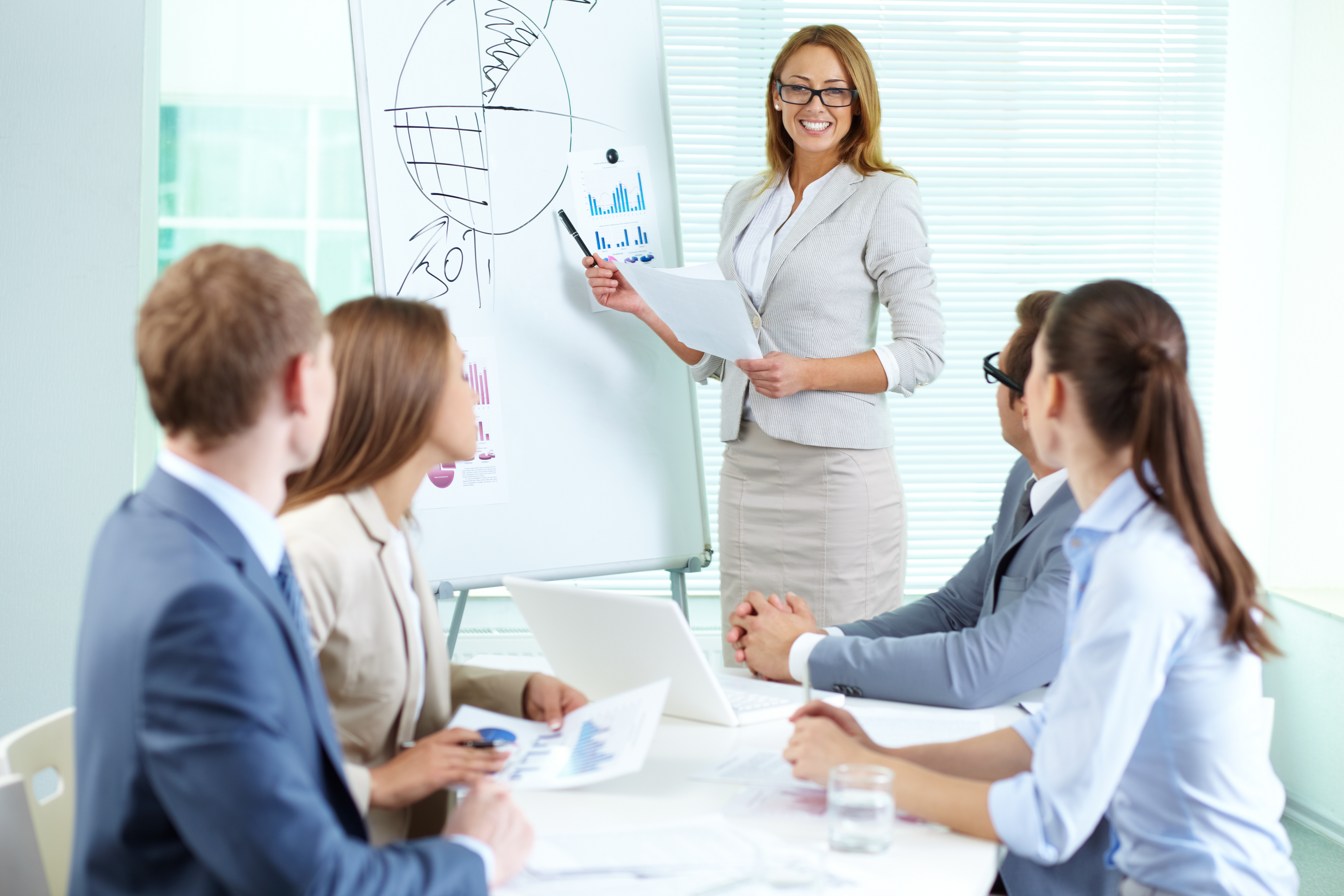 Confident businesswoman explaining something to colleagues at a board meeting representing diversity in an executive board. 