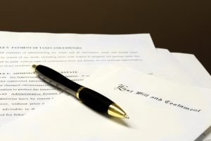 Image of a pen laying on top of papers that are a last will and testament for Estate Planning. 