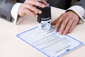 Close-up of male hands stamping a power of attorney document. 