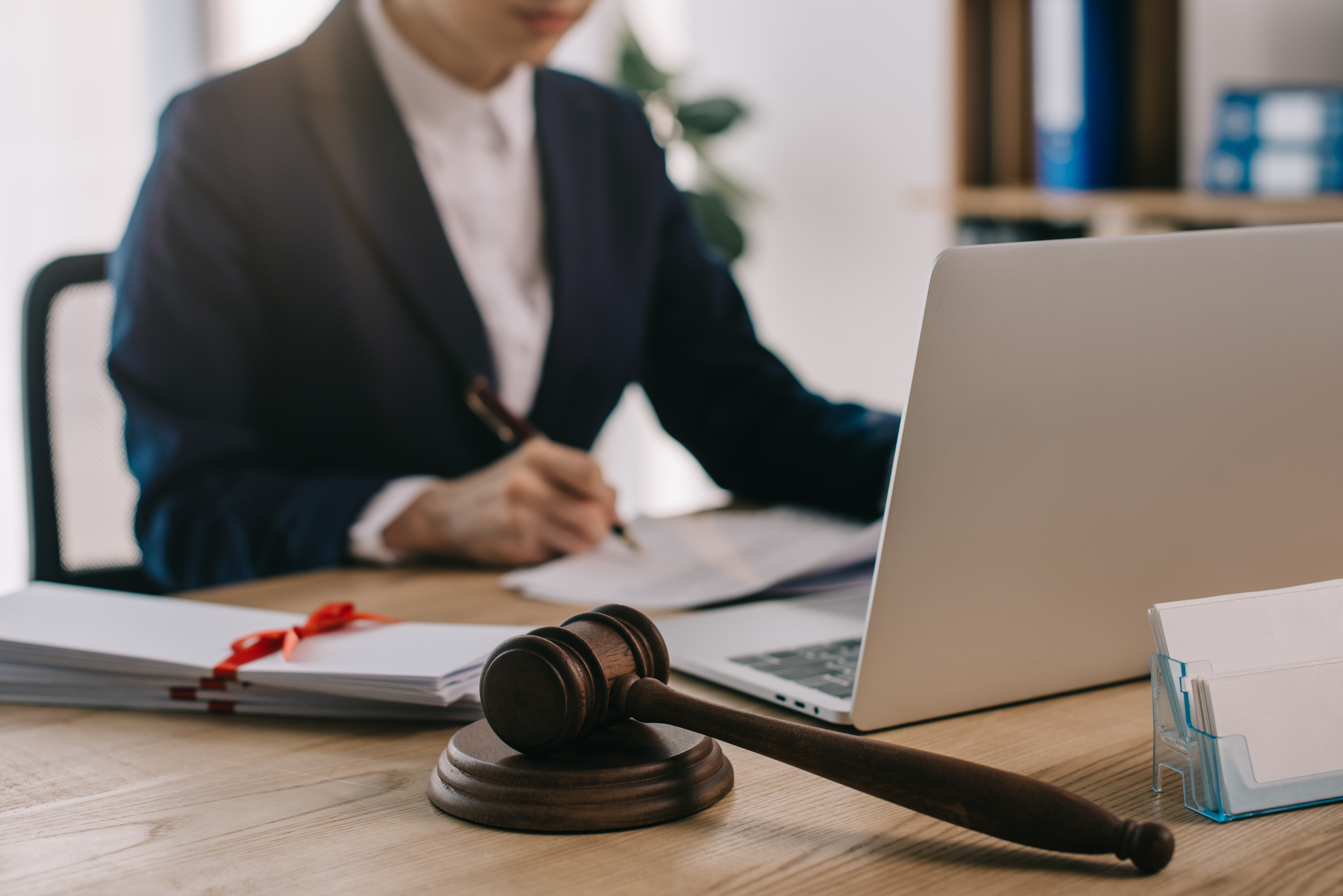 Female lawyer reviewing contract with a laptop and hammer and gavel. 