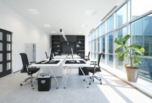 Image of a bright, light-filled and modern office interior with large windows overlooking the city, representing keeping office space after the Covid-19 pandemic. 