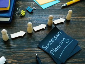 Business Succession planning sign and figurines with arrows representing legal issues with business succession planning. 