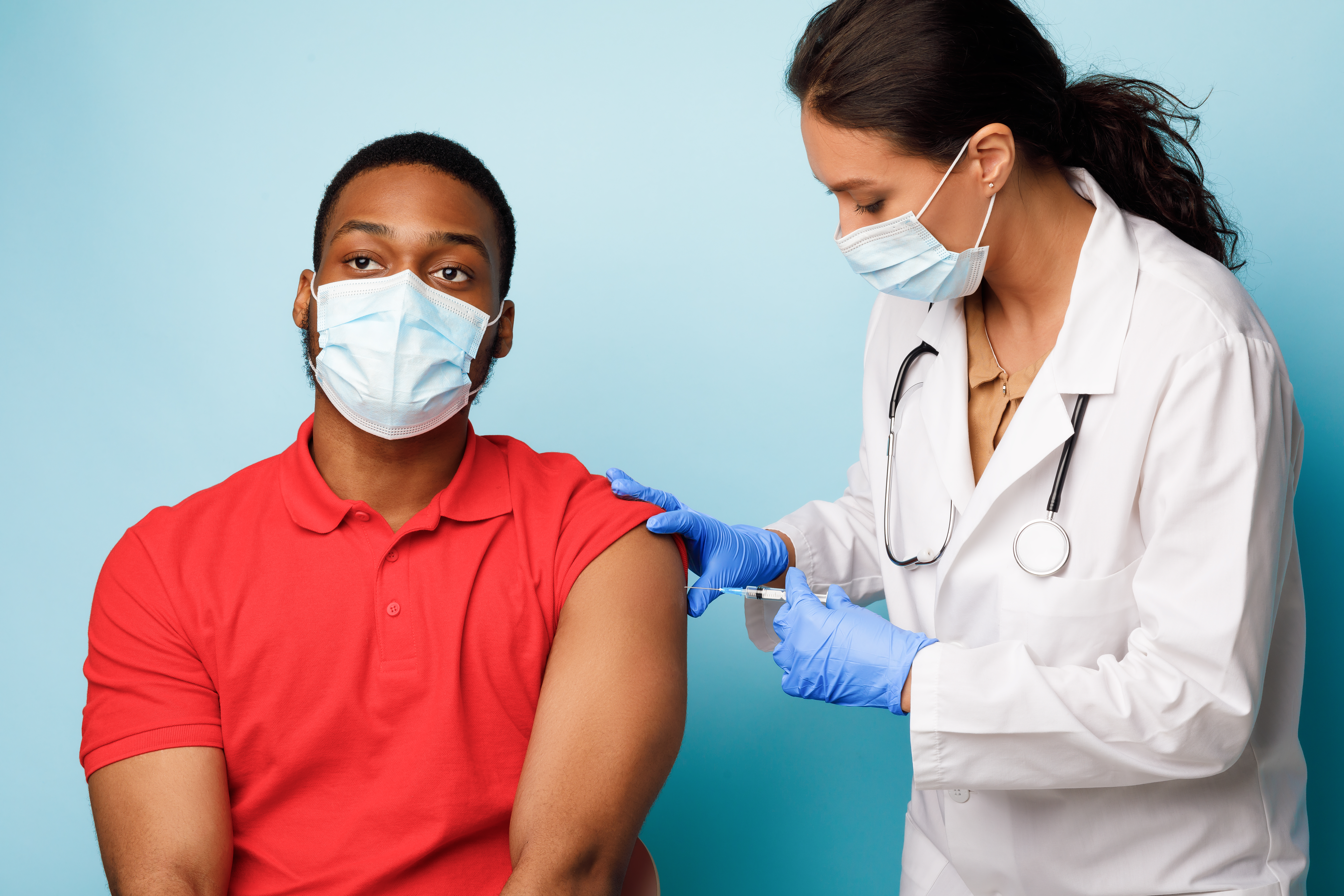African American man getting Covid-19 vaccine symbolizing employer compliance with federal vaccine mandate requirements. 