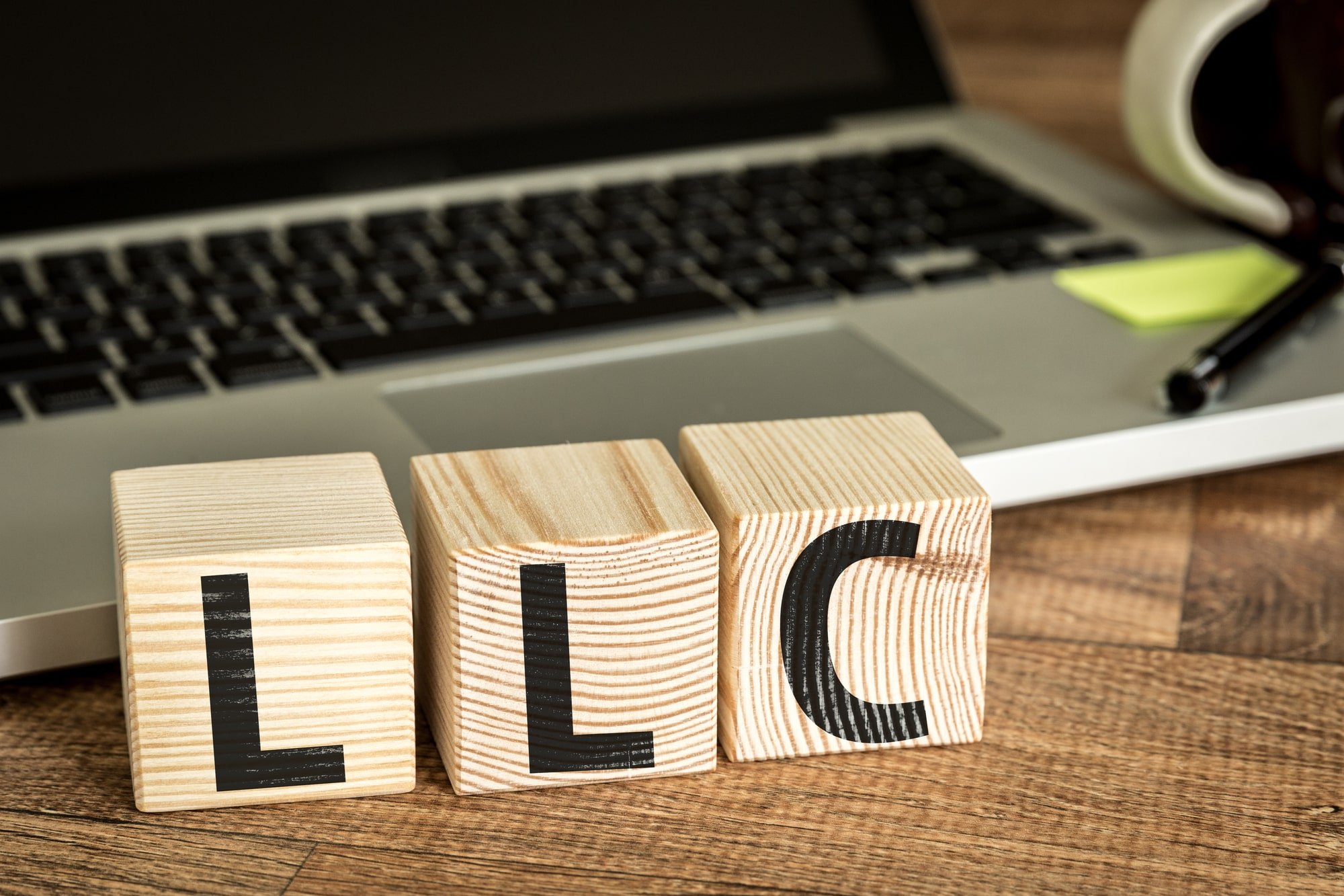 Image of a laptop with blocks that spell "LLC".