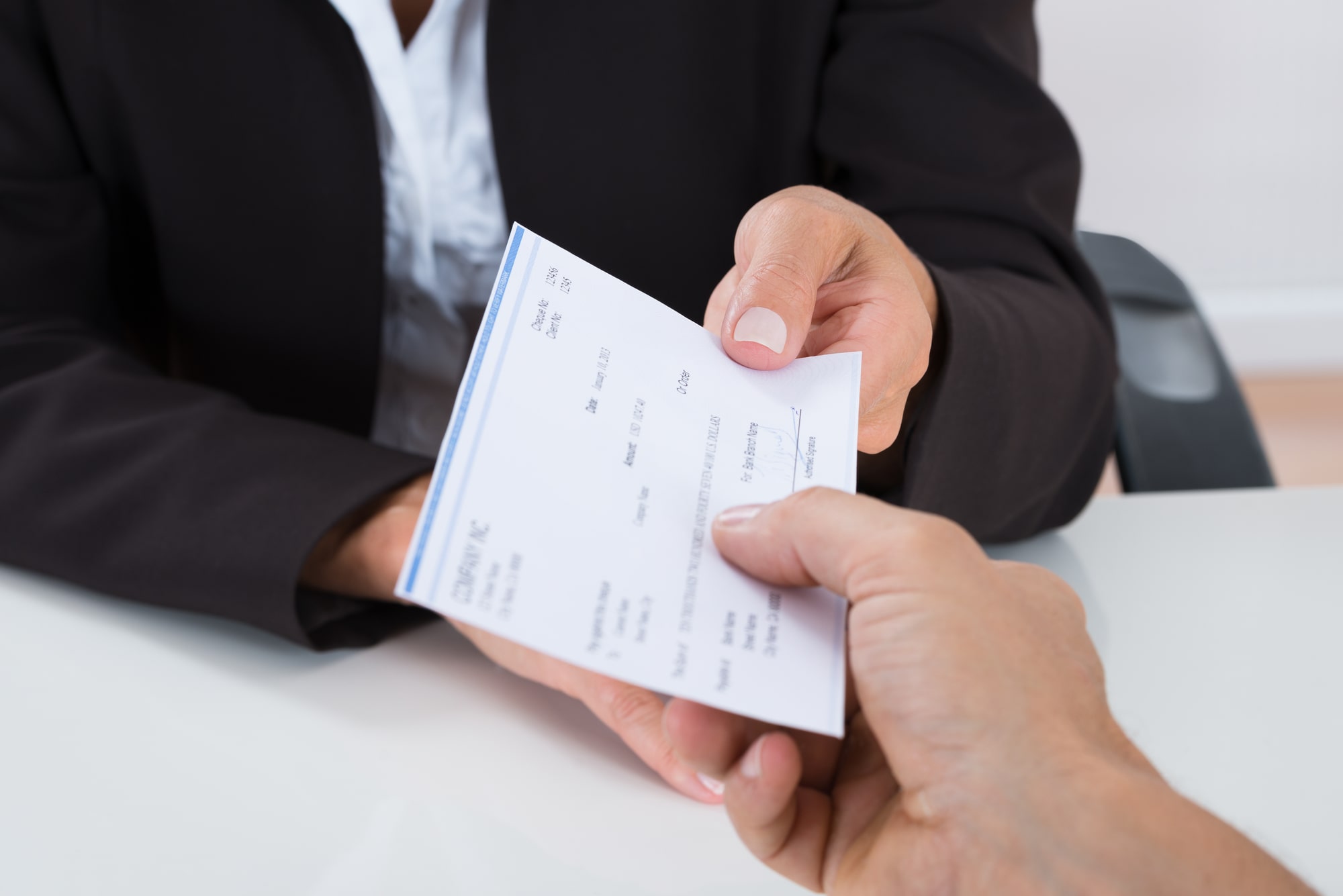 Image of an employee receiving a paycheck symbolizing pay transparency.
