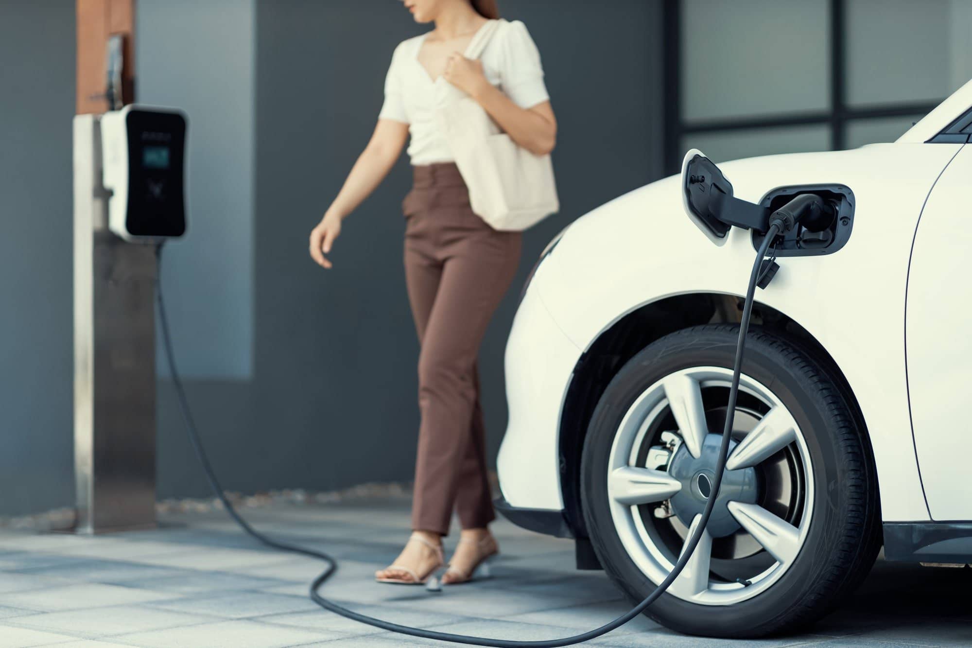 image of woman charging her EV at home.
