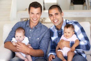 Two fathers holding two babies